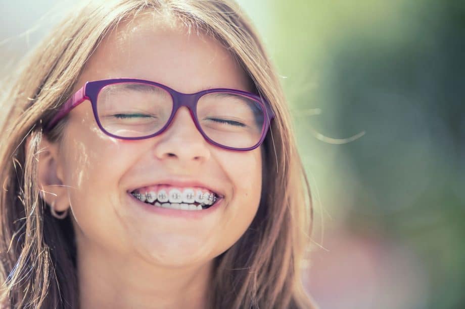 girl wearing braces and smiling 920x613